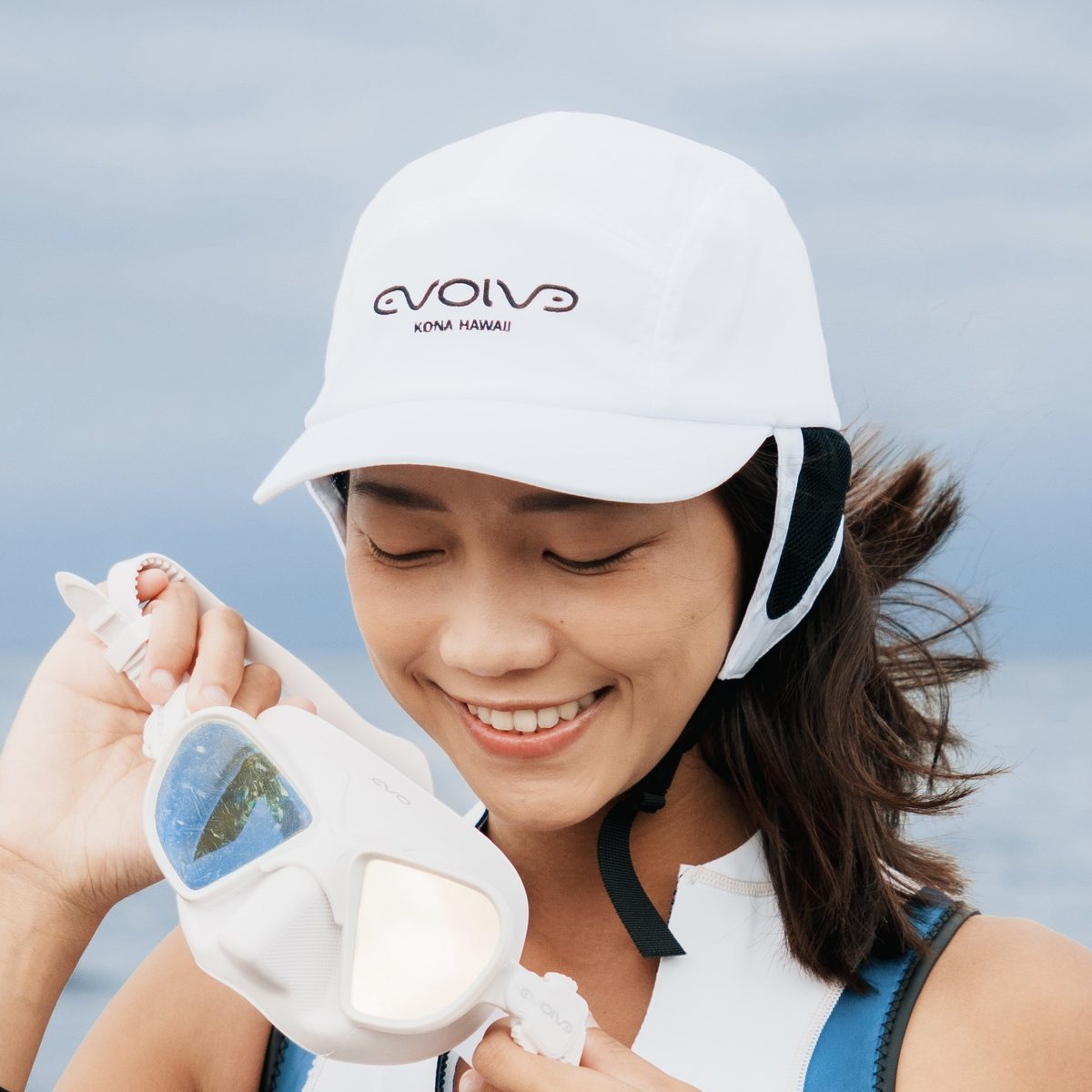 白いAquaCapを着用して海で過ごす女性